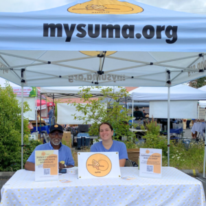 photo of two people sitting a market booth